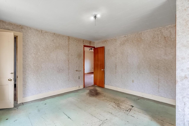 unfurnished room with baseboards
