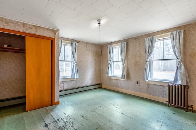 interior space featuring baseboard heating, radiator heating unit, and multiple windows