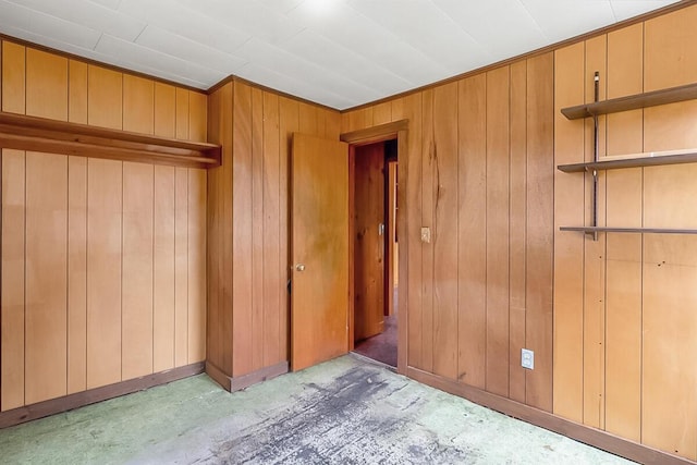 unfurnished bedroom featuring wooden walls