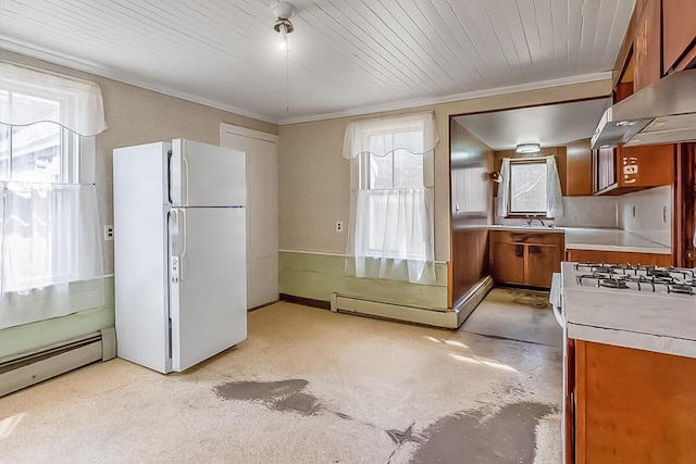 kitchen with wall chimney exhaust hood, light countertops, brown cabinets, and white appliances