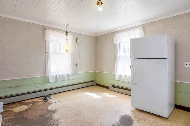 unfurnished dining area featuring a baseboard heating unit, crown molding, and plenty of natural light