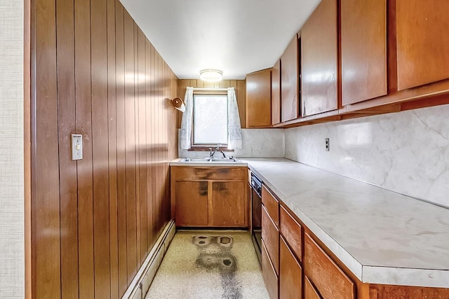 kitchen with a sink, light countertops, wooden walls, dishwasher, and brown cabinetry