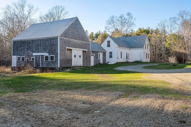 view of home's exterior with a lawn, an outdoor structure, and a barn