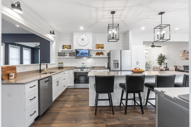 17 Wadlin Rd, Biddeford, ME 04005 - kitchen featuring stainless steel appliances, a sink, a chandelier, open shelves, and a kitchen breakfast bar