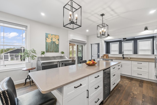 17 Wadlin Rd, Biddeford, ME 04005 - kitchen with beverage cooler, a chandelier, recessed lighting, a sink, and white cabinetry