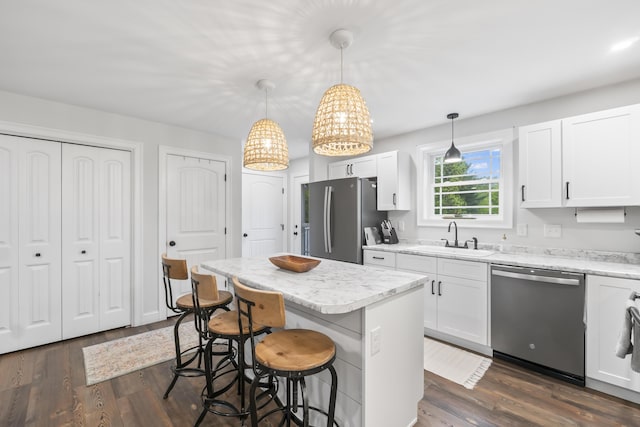 17 Wadlin Rd, Biddeford, ME 04005 - kitchen with appliances with stainless steel finishes, a sink, a kitchen island, a breakfast bar area, and white cabinetry