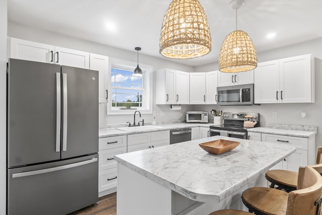 17 Wadlin Rd, Biddeford, ME 04005 - kitchen featuring appliances with stainless steel finishes, a sink, white cabinets, and a breakfast bar