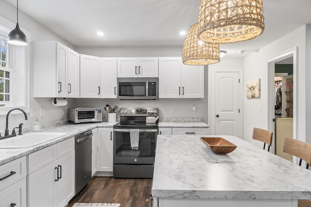 17 Wadlin Rd, Biddeford, ME 04005 - kitchen with appliances with stainless steel finishes, a sink, dark wood finished floors, white cabinetry, and a kitchen island