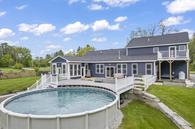 17 Wadlin Rd, Biddeford, ME 04005 - rear view of house featuring a wooden deck, roof with shingles, an outdoor pool, and a lawn