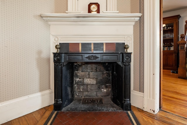546 Main St, Westbrook, ME 04092 - detailed view of a fireplace with flush hearth, wallpapered walls, and wood finished floors