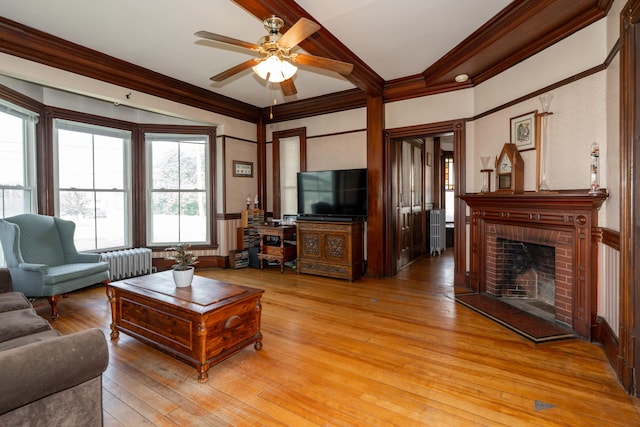 546 Main St, Westbrook, ME 04092 - living area with ornamental molding, a ceiling fan, a fireplace, light wood finished floors, and beamed ceiling