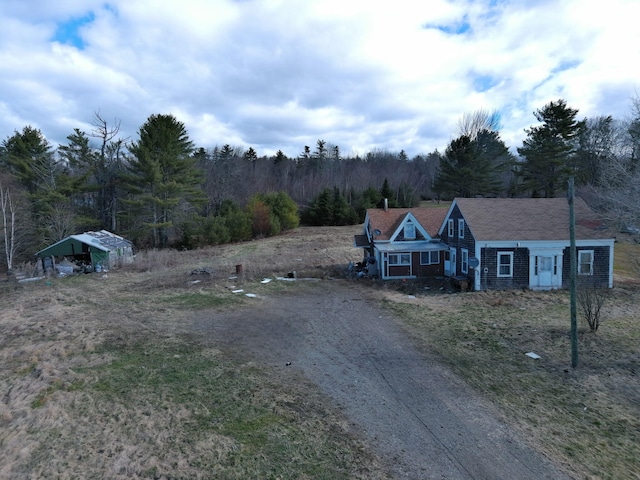 exterior space featuring a forest view and driveway