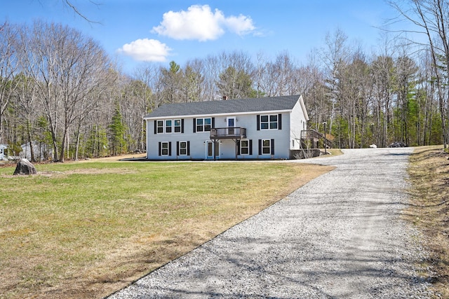 view of front facade with a front lawn, driveway, and a deck