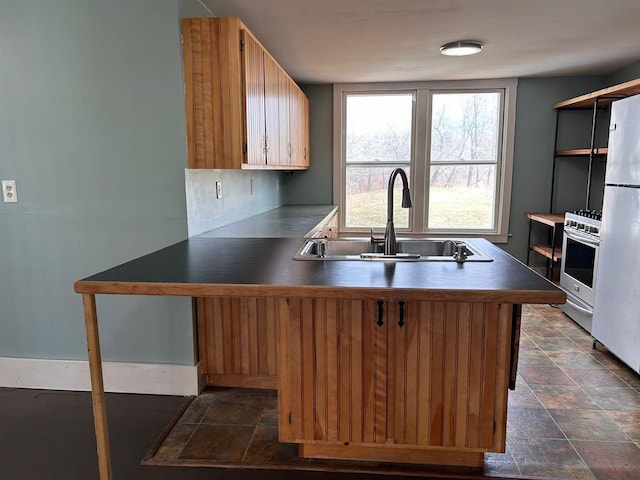 6 Naskeag Rd, Brooklin, ME 04616 - kitchen with a sink, a peninsula, stainless steel gas range oven, stone finish floor, and dark countertops