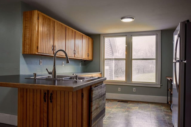 6 Naskeag Rd, Brooklin, ME 04616 - kitchen featuring freestanding refrigerator, baseboards, brown cabinetry, a sink, and dark countertops