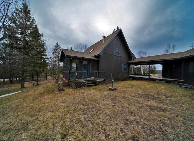 view of side of property featuring a yard and a deck
