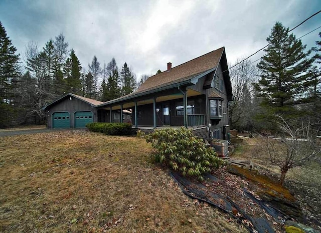 view of side of home featuring an attached garage, a chimney, and a sunroom