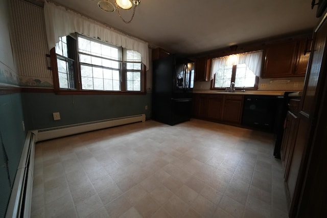 kitchen with a baseboard radiator, a healthy amount of sunlight, and black appliances