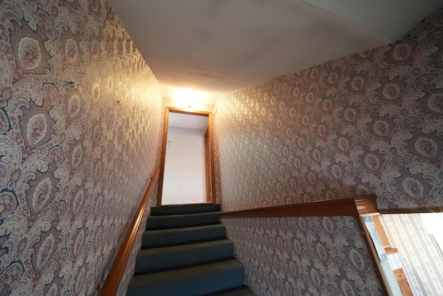 staircase with wallpapered walls