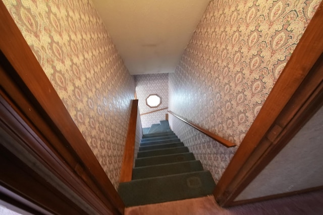stairway featuring wallpapered walls and carpet floors