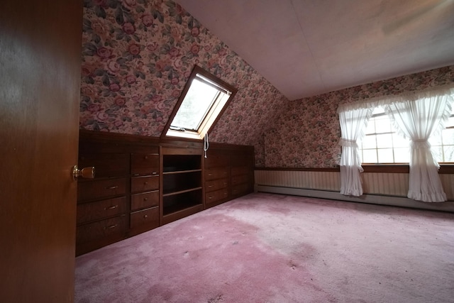bonus room with a baseboard heating unit, wallpapered walls, a skylight, and wainscoting