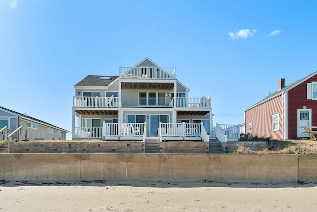 view of front of property featuring stairs and a balcony