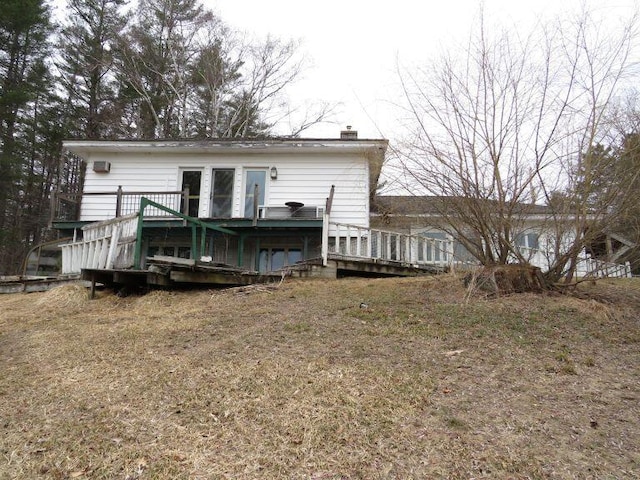 back of house with a chimney and a deck