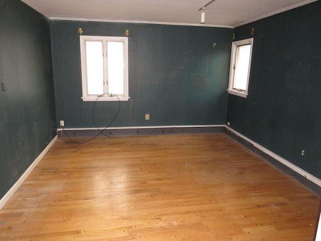 unfurnished room featuring baseboards, ornamental molding, and wood finished floors