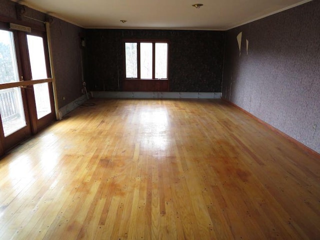 unfurnished room featuring crown molding, french doors, and light wood-style floors