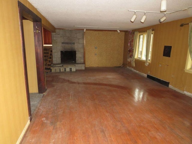 unfurnished living room with rail lighting, light wood-type flooring, and a fireplace