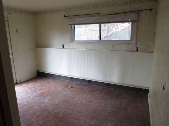 unfurnished room with wood walls