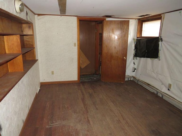 basement featuring baseboards and wood finished floors