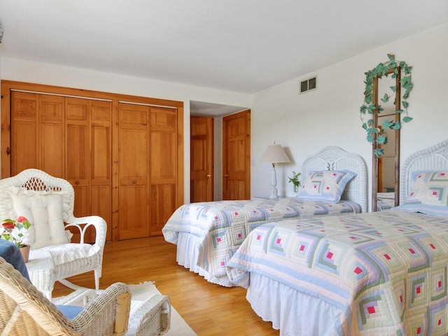 bedroom featuring a closet, visible vents, and light wood-style floors