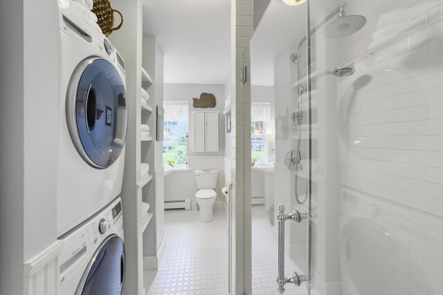 22 Porter Rd, Belfast, ME 04915 - bathroom with a baseboard heating unit, an enclosed shower, stacked washing maching and dryer, and toilet
