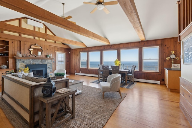 1 Moore Ln, Biddeford, ME 04005 - living room featuring a baseboard radiator, wood walls, a stone fireplace, light wood-type flooring, and ceiling fan