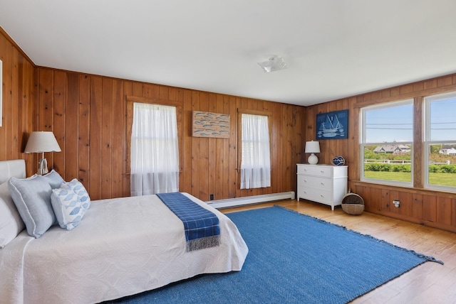 1 Moore Ln, Biddeford, ME 04005 - bedroom featuring a baseboard heating unit, multiple windows, wood finished floors, and wooden walls