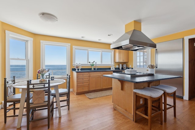 1 Moore Ln, Biddeford, ME 04005 - kitchen featuring island exhaust hood, a kitchen breakfast bar, dark countertops, stainless steel appliances, and light wood-style flooring