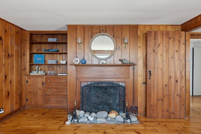 1 Moore Ln, Biddeford, ME 04005 - living area with hardwood / wood-style flooring, wooden walls, and a fireplace with flush hearth