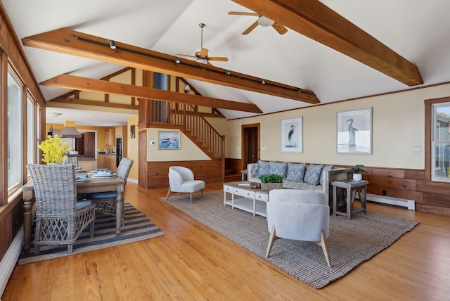 1 Moore Ln, Biddeford, ME 04005 - living area featuring baseboard heating, light wood-style flooring, ceiling fan, stairway, and wooden walls