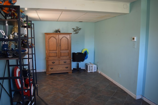 interior space featuring baseboards and a paneled ceiling