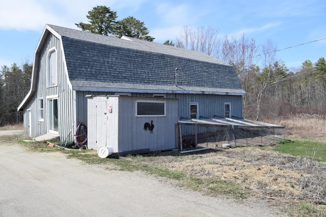 view of property exterior with roof with shingles and a gambrel roof