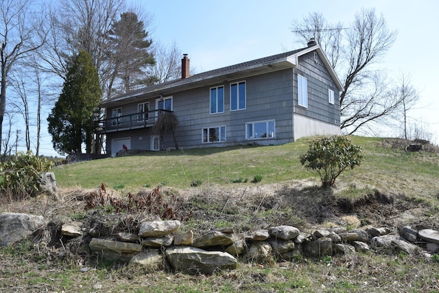 back of property featuring a lawn, a wooden deck, and a chimney