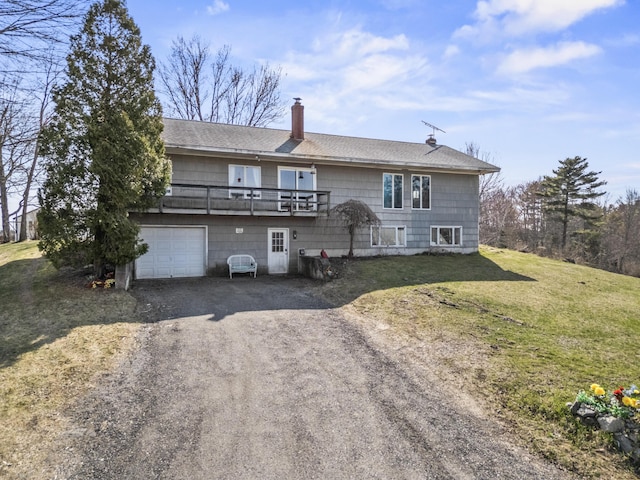 back of house with roof with shingles, a garage, dirt driveway, a chimney, and a yard