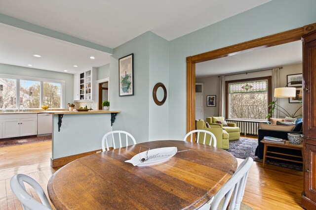 dining space with radiator, recessed lighting, a wealth of natural light, and light wood-style flooring
