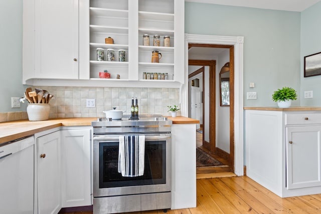 kitchen with backsplash, white cabinetry, wood counters, and electric stove