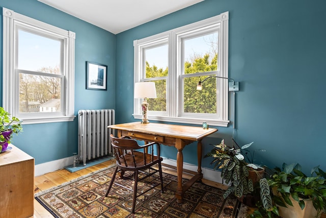 office area with baseboards, radiator heating unit, and wood finished floors