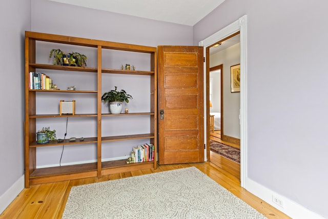 unfurnished room with baseboards and light wood-style floors