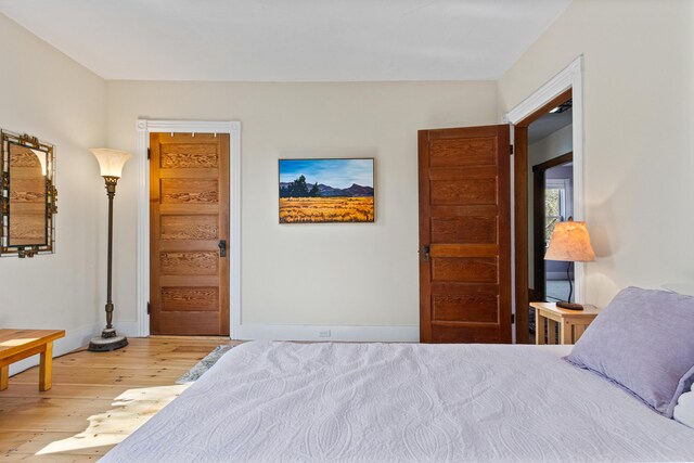 bedroom with baseboards and wood finished floors