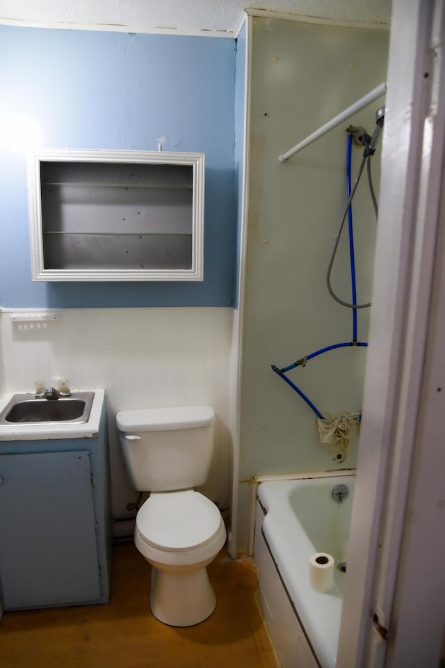 bathroom with wood finished floors, bathing tub / shower combination, vanity, and toilet
