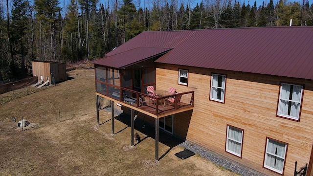 476 N Rd, Medford, ME 04463 - back of house with a sunroom, a deck, a wooded view, and metal roof